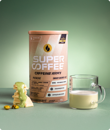 Lata SuperCoffee Pistache 380g ao lado de copo servido e chocolate branco com calda de pistache, em fundo verde claro.