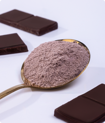 Colher dourada com pó de SuperCoffee sabor chocolate, cercada por pedaços de chocolate ao leite.