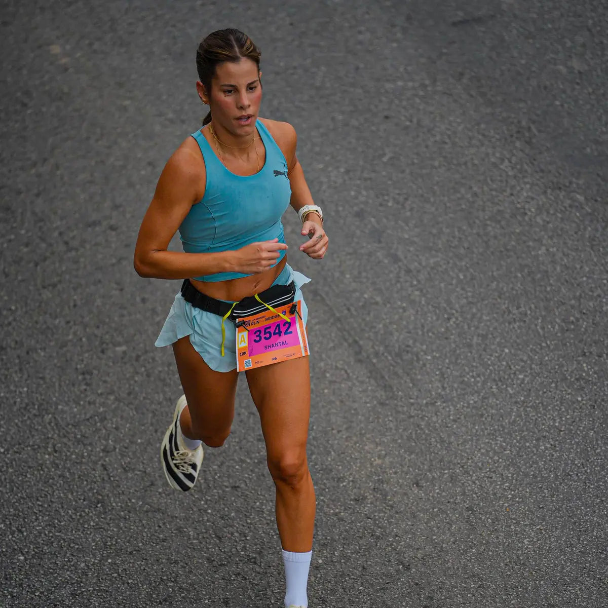 Shantal Verdelho correndo uma prova de 10 km, de regata azul e com o número de peito 3542.